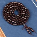 Macro detail of 108 blood sandalwood beads featuring gold flecks and a Chinese knot tassel - Black-Red Gold Star 6mm*108 Beads [Old Material]