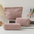 Three-piece knitted striped makeup bag set in purple and yellow on a white desk - Purple Stripe
