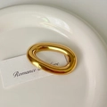 Polished golden oval stainless steel brooch shown on an elegant ceramic plate - 5# Gold O-Shape Brooch