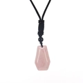 Detailed view of a hexagonal pink crystal pendant with a black braided cord necklace - Rose Quartz