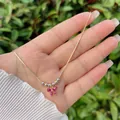 Detail of 18K gold plated necklace with purple zircon bowtie and imitation pearls - Burgundy