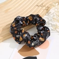 Detail of Halloween scrunchie with pumpkin and skull prints on silk-like fabric - Halloween #3 (Black Skeleton Star)