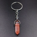 Macro detail of a hexagonal pink crystal pendant attached to a silver keychain - Watermelon red