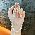Beaded phone lanyard with pearls, iridescent crystals, and a sparkling heart pendant. - White