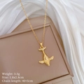 Detailed view of gold whale pendant with clear crystals on a beige jewelry display box - 3D Micro Paved Whale Style (A224) / Gold