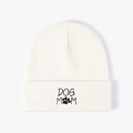 White knit beanie with black Dog Mom embroidery and paw print on a clean white background - One Size / White