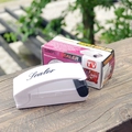 Portable mini bag sealer in white for plastic food bags shown on a wooden texture surface - Classic Old Style / White