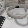 Macro detail of a silver glitter padded headband featuring a handmade black fabric label - Silver Grey
