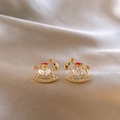 Nahaufnahme der vergoldeten Schaukelpferd-Ohrringe mit Zirkonia und roten Emaille-Details - 14# Silberohrstecker - Strass Emaille hohles Pferd