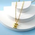 Golden 3D puffy letter E pendant necklace on minimalist white geometric display stand - Letter E(E)