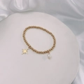 Detail of gold beaded bracelet featuring a pearl charm and star pendant on silk - Gold-Eight-Pointed Star
