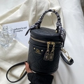 Schwarze zylindrische Handtasche mit strukturiertem Leder und gemustertem Seidenschal - Schwarz