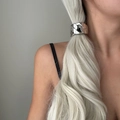 Close-up of a chunky silver metal chain hair tie on a platinum blonde ponytail style - Chain Style / Silver
