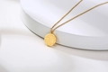 Detailed view of the gold stainless steel necklace featuring a round Fu pendant charm - Fu Xi Round Pendant (双面福囍) / Gold
