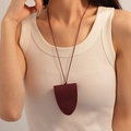 Dettaglio macro del ciondolo a cuore in ecopelle bordeaux con sottile cordino - 6# Collana Maglione Piccola Borsa in Pelle Triangolo Rosso Vino