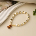 Détail d'un bracelet en perles avec perles dorées et un joli pendentif d'ours 3D - Ours Brun en Haut Jaune