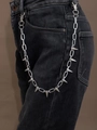 Detailopname van een zilveren punk broekketting met scherpe studs op zwarte spijkerbroek - X500 Zilver