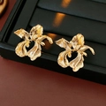 Macro-opname van gouden onregelmatige bloemoorbellen met orchideevorm op standaard - Goud