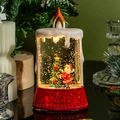 Dettaglio candela LED natalizia con Babbo Natale e glitter rotanti all'interno dell'acqua - Ragazza con Albero di Natale