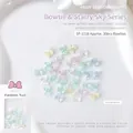 Detailopname van 6,5x8mm strikvormige hars nagelbedeltjes in diverse zachte pastelkleuren - Kleine strik (SP-1118)
