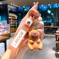Cute Capybara soft rubber keychain with a yellow BOOM strap and golden metal ring - B443-2 Sitting