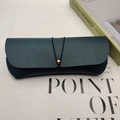 Dark green leather sunglasses case with lychee texture and gold bead closure detail - Dark Green