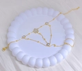 Detailed macro view of gold-plated finger bracelet with pearl and flower charm - Flower
