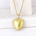 Golden heart locket necklace with floral engraving on a white marble background - Vine Flower Heart/Gold