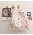 Detail eines weißen Leinwand-Rucksacks mit Blumenmuster und süßem Plüschblumen-Anhänger - Einzelne Tasche / Blume