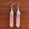 Detail of rose quartz hexagonal prism earrings with silver fishhook wires on wood - Rose Quartz