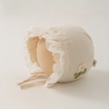 Detail der Baby-Baumwollhaube mit zarter Spitze und gehäkelter Blume für Neugeborene - 35-45cm 0-12 Monate / Beige