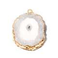Close-up of a natural agate slice pendant with gold-plated edges and blue crystal core - White