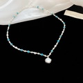 Beaded necklace with blue and white pearls and a silver oval shell pendant on velvet - Silver-Blue