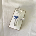 Silver butterfly bracelet and ring set with white pearls and blue gemstones in a jewelry box - Blue