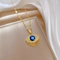 Luxurious gold devil eye necklace with blue center and crystals on beige padding - Gold Painted Evil Eye