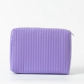 Detail of light purple quilted makeup bag featuring vertical lines and smooth zipper - 25*7.5*17cm / Lavender