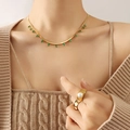 Golden necklace with green zircon pendants and pearl ring on a model with knitwear - Gold Color with Green Zircon (P340)