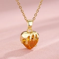 Golden melting heart pendant necklace with orange zircon crystal on pink background - Orange