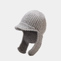 Détail du bonnet en maille grise avec protège-oreilles, visière courte et texture épaisse en laine - Taille unique / Gris clair