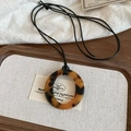 Close-up of a vintage resin tortoiseshell ring pendant on a black cord over linen cloth - 38# Necklace - Brown-Round