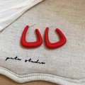 Detailed macro view of matte red geometric triangle earrings with silver needle posts - Red Triangle Pattern