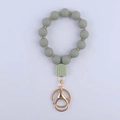 Dettaglio del portachiavi in perline di silicone grigio-verde con strass e chiusura dorata - Verde Salvia