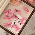 Close-up of pink ribbon bow hair clips with metal duckbill base on a pearl jewelry tray - Rose Pink