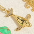 Macro-opname van walvisstaart hanger met gouden afwerking en sprankelende zirkoon steen - Dolfijn Ketting