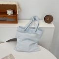 Dettaglio della borsa tote in tela azzurra con ricamo floreale sui manici - Azzurro