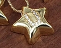 Star shaped gold necklace pendant with letter U cubic zirconia on dark wood - Letter U