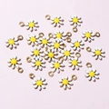 Flat lay macro of small white and yellow daisy flower pendants for DIY jewelry making - White & Yellow