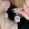 Boucles d'oreilles élégantes en nœud avec pierres roses rectangulaires sur un mannequin - 30# Style Diamant Carré Nœud Rose (HE3995)