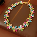 Dettaglio collana vintage fiori dorati con gemme colorate su sfondo di pelle marrone - Collana - Fiore Multicolore