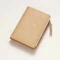 Close-up of beige leather wallet with Forever Lucky text and smooth metal zipper details - Yellow